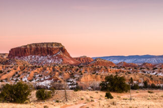 Pink twilight softly illuminated a mesa and surrounding rocks near Ghost Ranch in northern New Mexico.