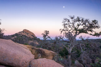 Turkey Peak was seen from a hiking trail on Enchanted Rock in the evening. Enchanted Rock State Natural Area is one of the most popular destinations for rock climbers in Texas.